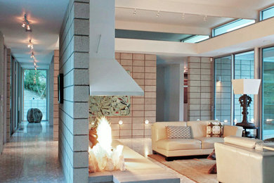 Large mid-century modern formal and enclosed marble floor living room photo in Los Angeles with white walls, a hanging fireplace and a metal fireplace