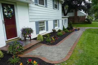 Photo of a front yard partial sun garden for summer in Philadelphia with a garden path and concrete pavers.