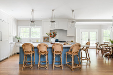 Example of a large beach style kitchen design in Boston with shaker cabinets, quartz backsplash and an island