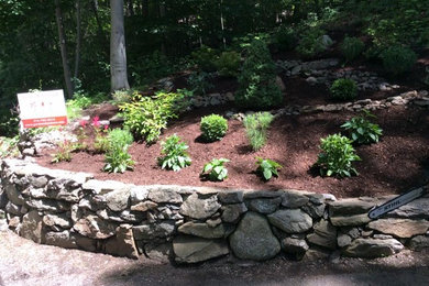 Inspiration for a mid-sized traditional partial sun hillside mulch landscaping in New York for summer.