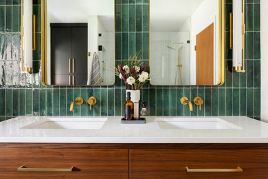 Пример оригинального дизайна: главная ванная комната среднего размера в современном стиле с плоскими фасадами, фасадами цвета дерева среднего тона, душем в нише, инсталляцией, зеленой плиткой, керамической плиткой, белыми стенами, полом из керамогранита, врезной раковиной, столешницей из искусственного кварца, серым полом, душем с распашными дверями, белой столешницей, нишей, тумбой под две раковины и напольной тумбой