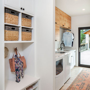 オースティンのカントリー風おしゃれな洗濯室 (アンダーカウンターシンク、フラットパネル扉のキャビネット、中間色木目調キャビネット、白い壁、左右配置の洗濯機・乾燥機) の写真