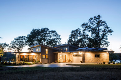 Inspiration for a mid-sized contemporary gray two-story stone exterior home remodel in Minneapolis with a shed roof