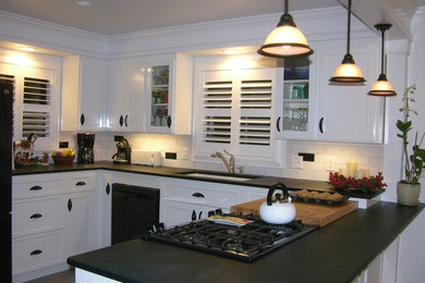 Inspiration for a mid-sized transitional u-shaped linoleum floor and gray floor open concept kitchen remodel in Other with an undermount sink, shaker cabinets, white cabinets, solid surface countertops, white backsplash, subway tile backsplash and black appliances