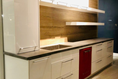 Small trendy single-wall concrete floor, gray floor and wood ceiling eat-in kitchen photo in San Francisco with an undermount sink, flat-panel cabinets, laminate countertops, yellow backsplash, porcelain backsplash, colored appliances, no island and gray countertops
