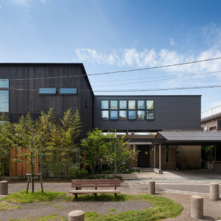 横浜のモダンスタイルのおしゃれな二階建ての家 (黒い外壁、陸屋根、金属屋根) の写真