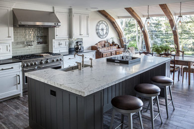 Inspiration for a large country eat-in kitchen in New York with a farmhouse sink, beaded inset cabinets, grey cabinets, marble benchtops, white splashback, stainless steel appliances, porcelain floors and with island.
