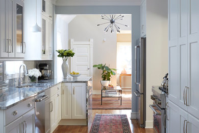 Kitchen - transitional galley medium tone wood floor kitchen idea in Chicago with an undermount sink, shaker cabinets, white cabinets, white backsplash, stainless steel appliances and a peninsula