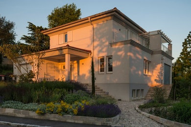 Mittelgroßes, Zweistöckiges Mediterranes Haus mit Putzfassade, weißer Fassadenfarbe und Walmdach in Sonstige