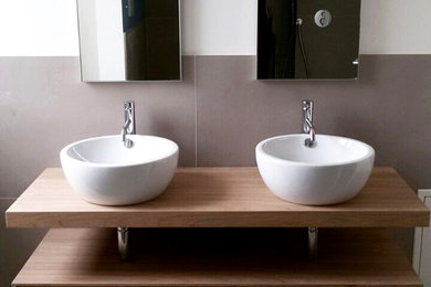 Design ideas for a modern bathroom in Other with light wood cabinets, gray tile, porcelain tile, porcelain floors and a vessel sink.
