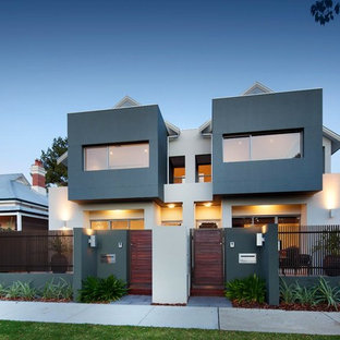 Idéer för mellanstora funkis grå flerfamiljshus, med två våningar, stuckatur och sadeltak