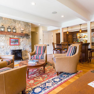 Foto de sótano con puerta de estilo americano, extra grande, con paredes blancas, suelo de madera en tonos medios, estufa de leña y marco de chimenea de piedra