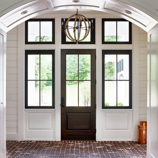 Idee per una porta d'ingresso country di medie dimensioni con pareti bianche, pavimento in mattoni, una porta singola, una porta in vetro e pavimento rosso