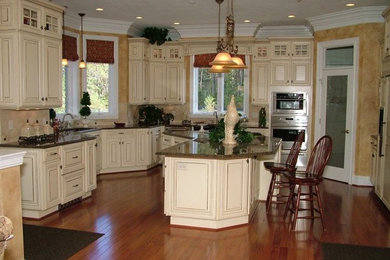 Example of a classic medium tone wood floor kitchen design in Other with distressed cabinets, granite countertops, an island and stainless steel appliances