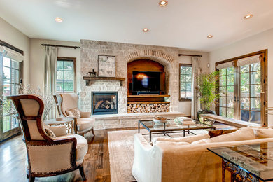 Inspiration for a large transitional formal and open concept dark wood floor living room remodel in Denver with white walls, a standard fireplace, a stone fireplace and a media wall