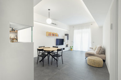 Diseño de salón contemporáneo pequeño con paredes blancas, suelo de baldosas de porcelana, televisor colgado en la pared y suelo gris