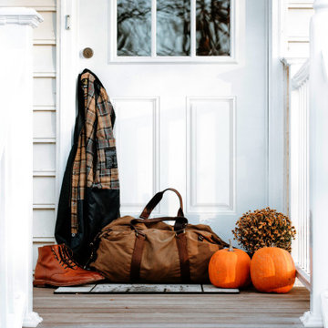 White fall decorated entry way of traditional style home with a white door