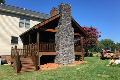 This is an example of a mid-sized craftsman back porch design in Charlotte with a fire pit, decking and a roof extension.