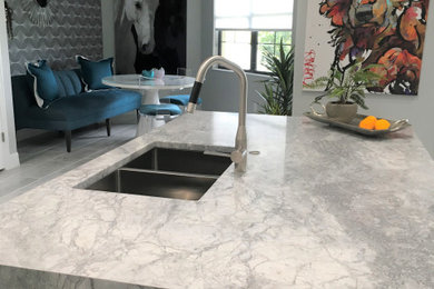 Open concept kitchen - mid-sized modern l-shaped porcelain tile and gray floor open concept kitchen idea in Tampa with an undermount sink, raised-panel cabinets, white cabinets, marble countertops, gray backsplash, subway tile backsplash, stainless steel appliances, an island and gray countertops