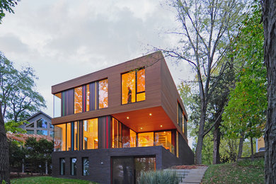 Contemporary three-storey exterior in Milwaukee with wood siding and a flat roof.