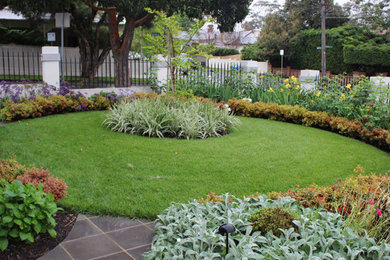 Photo of a mid-sized traditional front yard full sun formal garden for spring in Melbourne with with flowerbed and concrete pavers.
