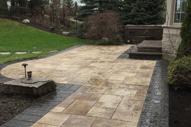 Inspiration for a large traditional backyard stone landscaping in Toronto.