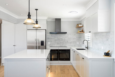 Eat-in kitchen - large l-shaped eat-in kitchen idea in Newcastle - Maitland with shaker cabinets, gray cabinets, quartz countertops, gray backsplash, marble backsplash, an island and white countertops