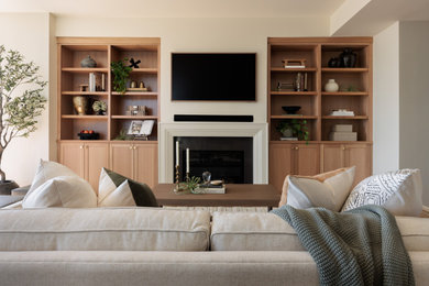 Example of a mid-sized transitional open concept light wood floor and beige floor living room library design in Seattle with beige walls, a standard fireplace, a stone fireplace and a wall-mounted tv