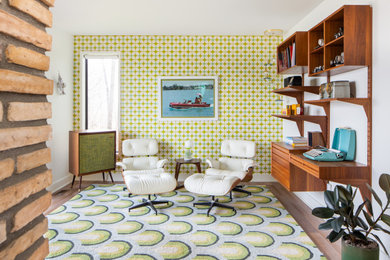 Living room library - mid-sized 1950s open concept medium tone wood floor, brown floor and wallpaper living room library idea in Detroit with white walls, a two-sided fireplace and a brick fireplace
