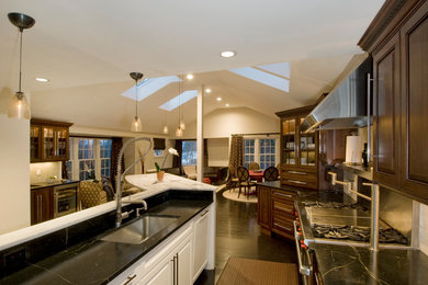 Inspiration for a large timeless dark wood floor eat-in kitchen remodel in Boston with an undermount sink, raised-panel cabinets, dark wood cabinets, marble countertops, white backsplash, stainless steel appliances, an island and subway tile backsplash