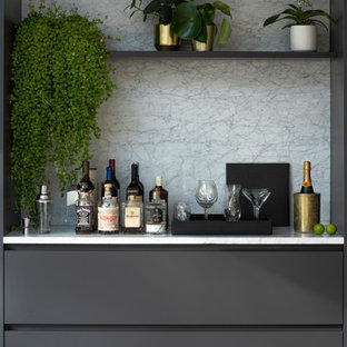 Foto de bar en casa contemporáneo, grande, con puertas de armario grises, encimera de mármol y suelo de madera clara