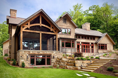 Inspiration for a large craftsman beige two-story wood and board and batten exterior home remodel in Milwaukee with a shingle roof and a gray roof