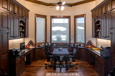 Large transitional built-in desk medium tone wood floor study room photo in Miami with beige walls