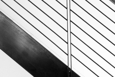 Minimalist wooden metal railing staircase photo in New York with wooden risers