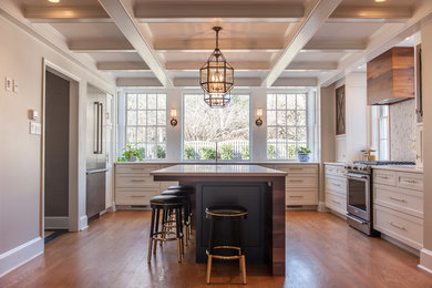 Kitchen - mid-sized transitional u-shaped medium tone wood floor and brown floor kitchen idea in Philadelphia with an undermount sink, white cabinets, white backsplash, stainless steel appliances, an island, white countertops and recessed-panel cabinets
