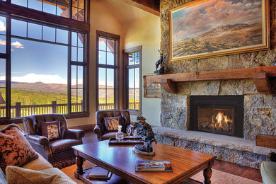 This is an example of a large country formal open concept living room with beige walls, medium hardwood floors, a standard fireplace, a stone fireplace surround, no tv and brown floor.