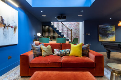 This is an example of a large contemporary fully buried basement in London with blue walls, medium hardwood floors, no fireplace and brown floor.