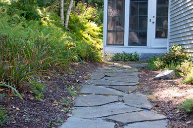 Inspiration for a large rustic side yard stone landscaping in Boston.