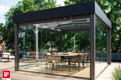 Photo of a contemporary deck in Other with a roof extension.