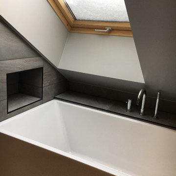 Badrum med walk-in shower, ångbad, snedtak och djupt takfönster.