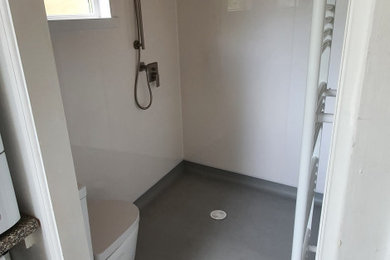 Modelo de cuarto de baño único y gris y blanco moderno de tamaño medio sin sin inodoro con sanitario de dos piezas, paredes blancas, aseo y ducha, lavabo encastrado, suelo gris, cuarto de baño y panelado