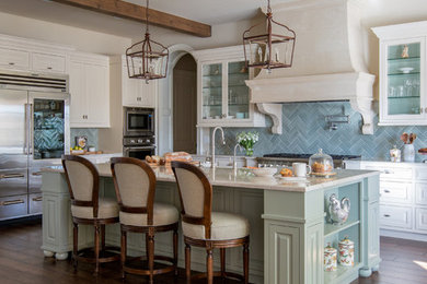 Large transitional l-shaped medium tone wood floor and brown floor eat-in kitchen photo in Jacksonville with a farmhouse sink, raised-panel cabinets, white cabinets, granite countertops, blue backsplash, ceramic backsplash, stainless steel appliances and an island