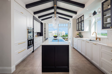 Inspiration for a mid-sized transitional galley ceramic tile, black floor and vaulted ceiling eat-in kitchen remodel in Miami with an undermount sink, shaker cabinets, white cabinets, quartz countertops, white backsplash, marble backsplash, paneled appliances, an island and white countertops