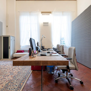 Inspiration for a large modern study in Florence with white walls, terracotta flooring, a freestanding desk and brown floors.