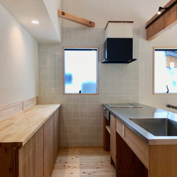 造り付けで作成したステンレス天板の造作キッチンと造作食器棚