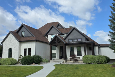 Huge transitional white two-story mixed siding and board and batten exterior home idea in Salt Lake City with a mixed material roof and a brown roof