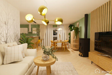 Diseño de salón abierto y blanco y madera campestre grande con paredes verdes, suelo de madera clara, estufa de leña, televisor colgado en la pared y madera