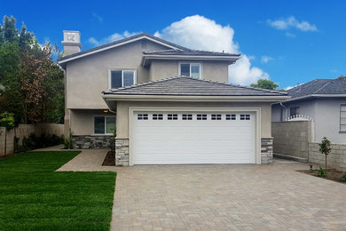 Beige two-story stucco exterior home photo in Los Angeles with a hip roof