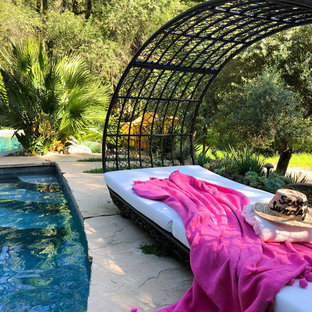 Photo of a mid-sized eclectic front yard custom-shaped natural pool in San Francisco with a hot tub and natural stone pavers.