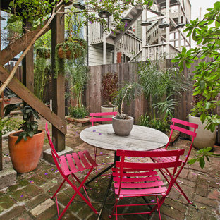 This is an example of a small victorian backyard patio in San Francisco with brick pavers.